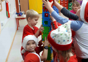Dzieci prezentują wieżę zbudowaną z klocków
